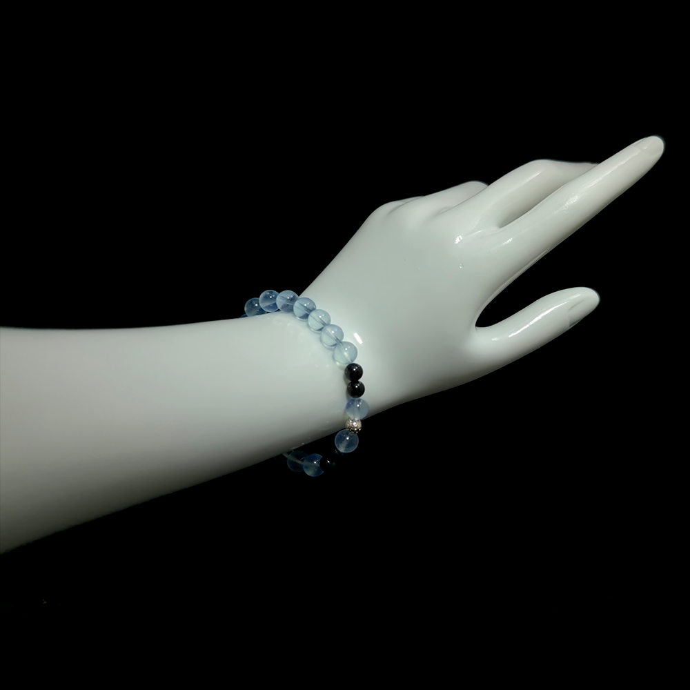 Aquamarine and Black Tourmaline bracelet worn on hand showing calming and protective energy jewelry