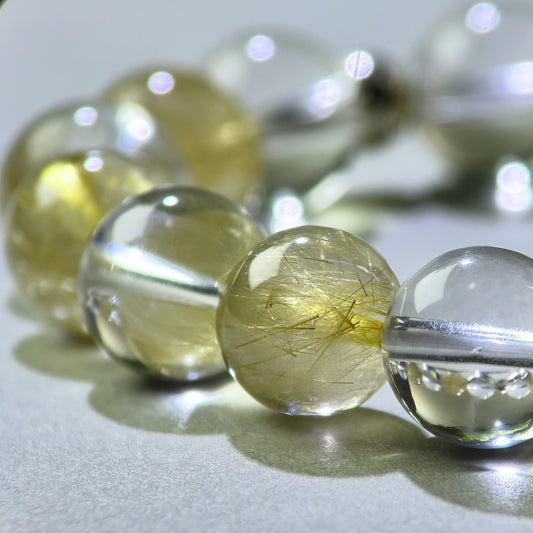 Close-up of Golden Rutilated Quartz and Clear Quartz beads in a crystal bracelet for focused communication