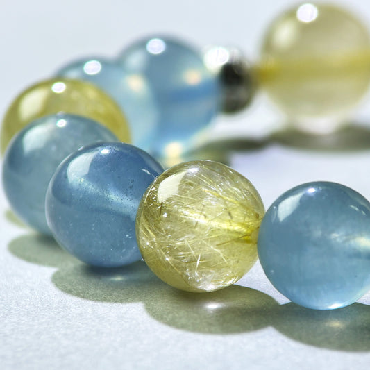 Close-up of Aquamarine and Golden Rutilated Quartz beads in a crystal bracelet for confident communication and stronger presence