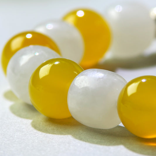 Close-up of Yellow Agate and White Hetian Jade beads in a crystal bracelet for calmer connection and emotional openness