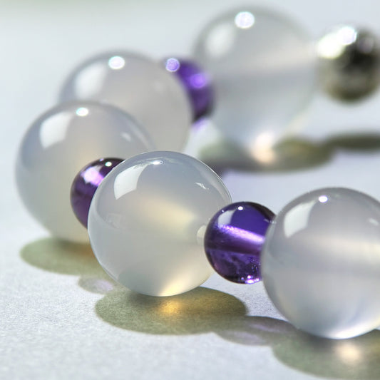 Close-up of White Agate and Amethyst beads in a crystal bracelet for a steadier speaking pace