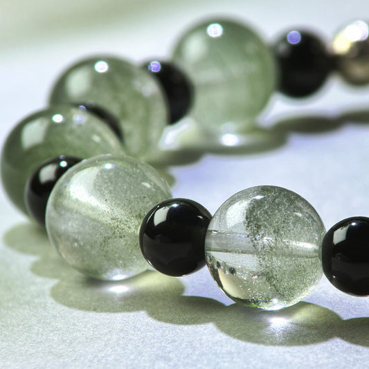 Close-up of Green Phantom Quartz and Obsidian beads in a crystal bracelet for staying steady in busy work environments