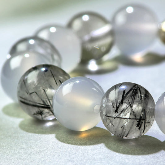 Close-up of White Agate and Black Rutilated Quartz beads in a crystal bracelet for calmer mental processing