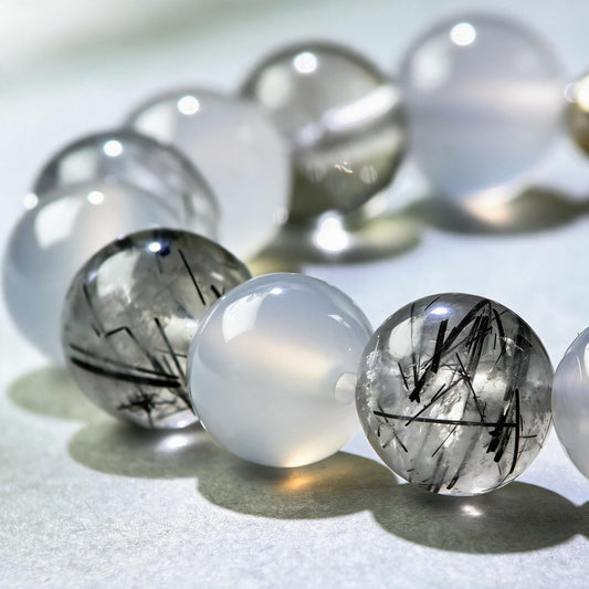 Close-up of White Agate and Black Rutilated Quartz beads in a crystal bracelet for calmer mental processing
