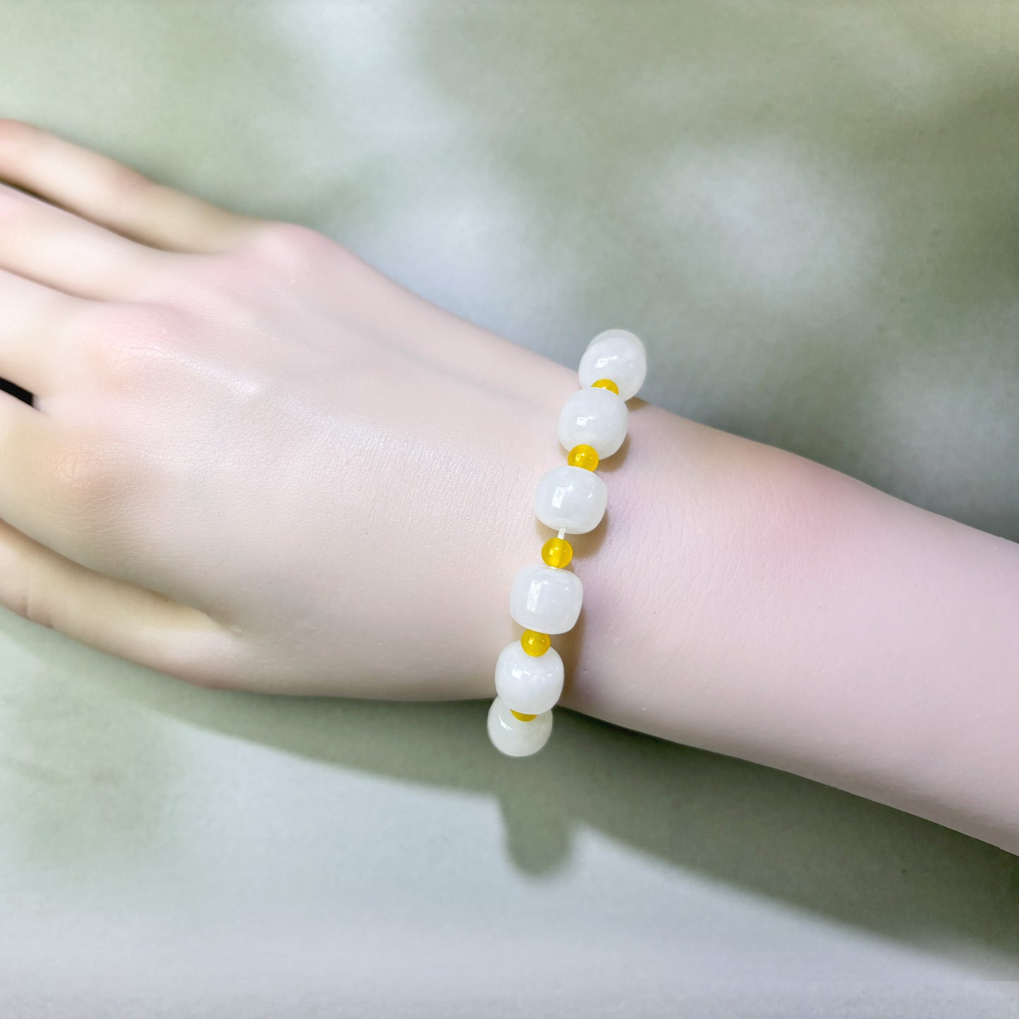 White Hetian Jade and Yellow Agate bracelet worn on wrist for greater ease during rest