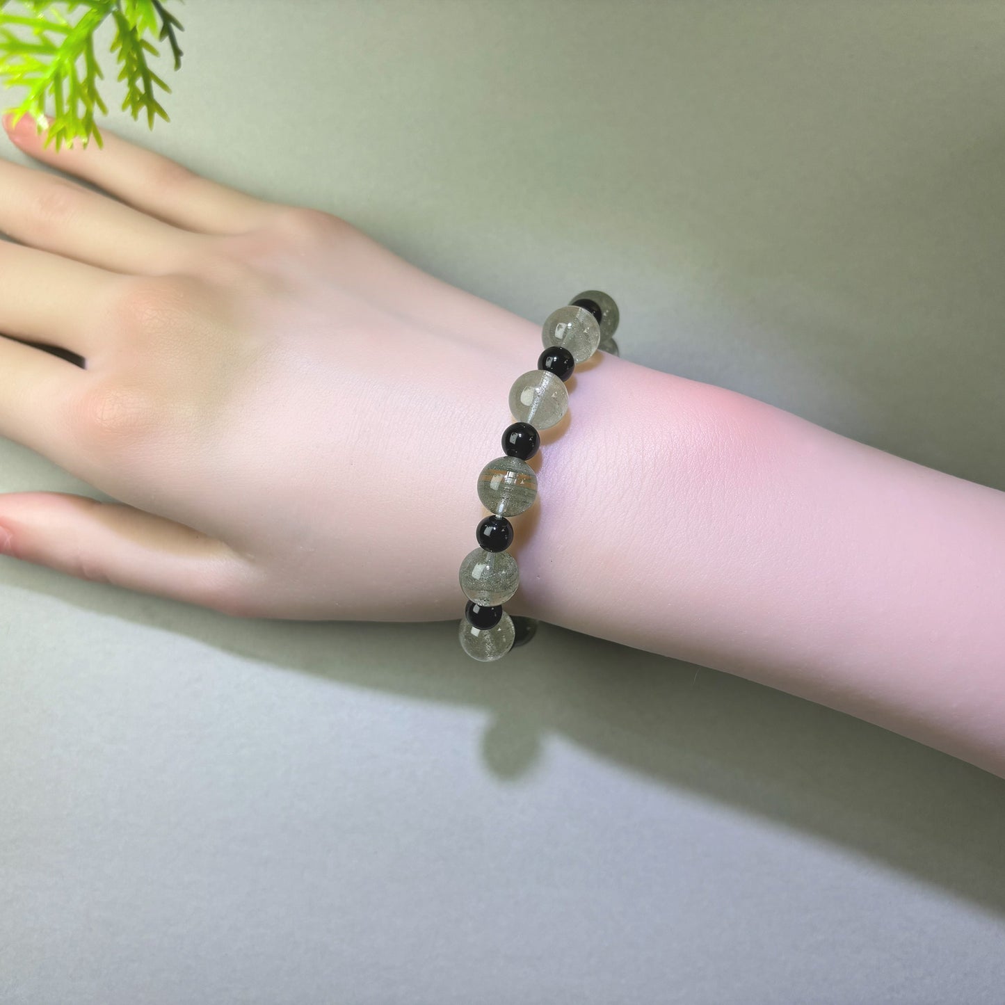 Green Phantom Quartz and Obsidian bracelet worn on wrist for reducing disruptions and keeping progress moving