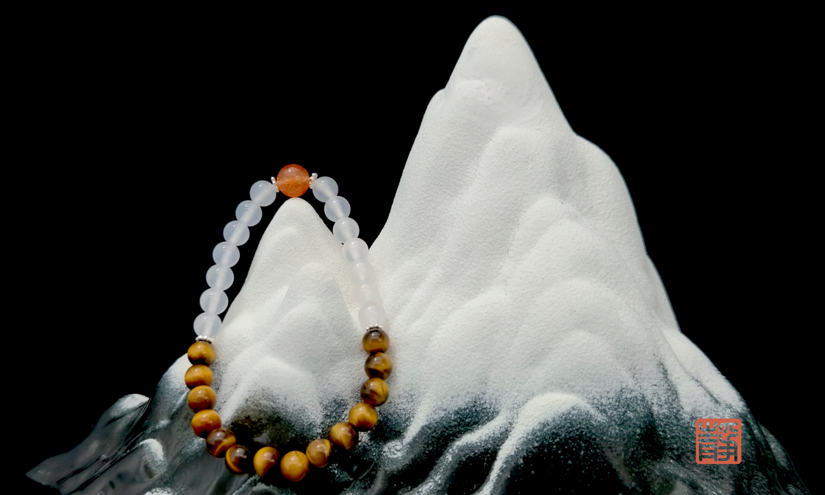 Wearable Feng Shui crystal bracelet featuring strawberry quartz, rose quartz, and white jade on a white stone background, symbolizing personalized energy matching and the wisdom behind tailored crystal recommendations - JING Balance