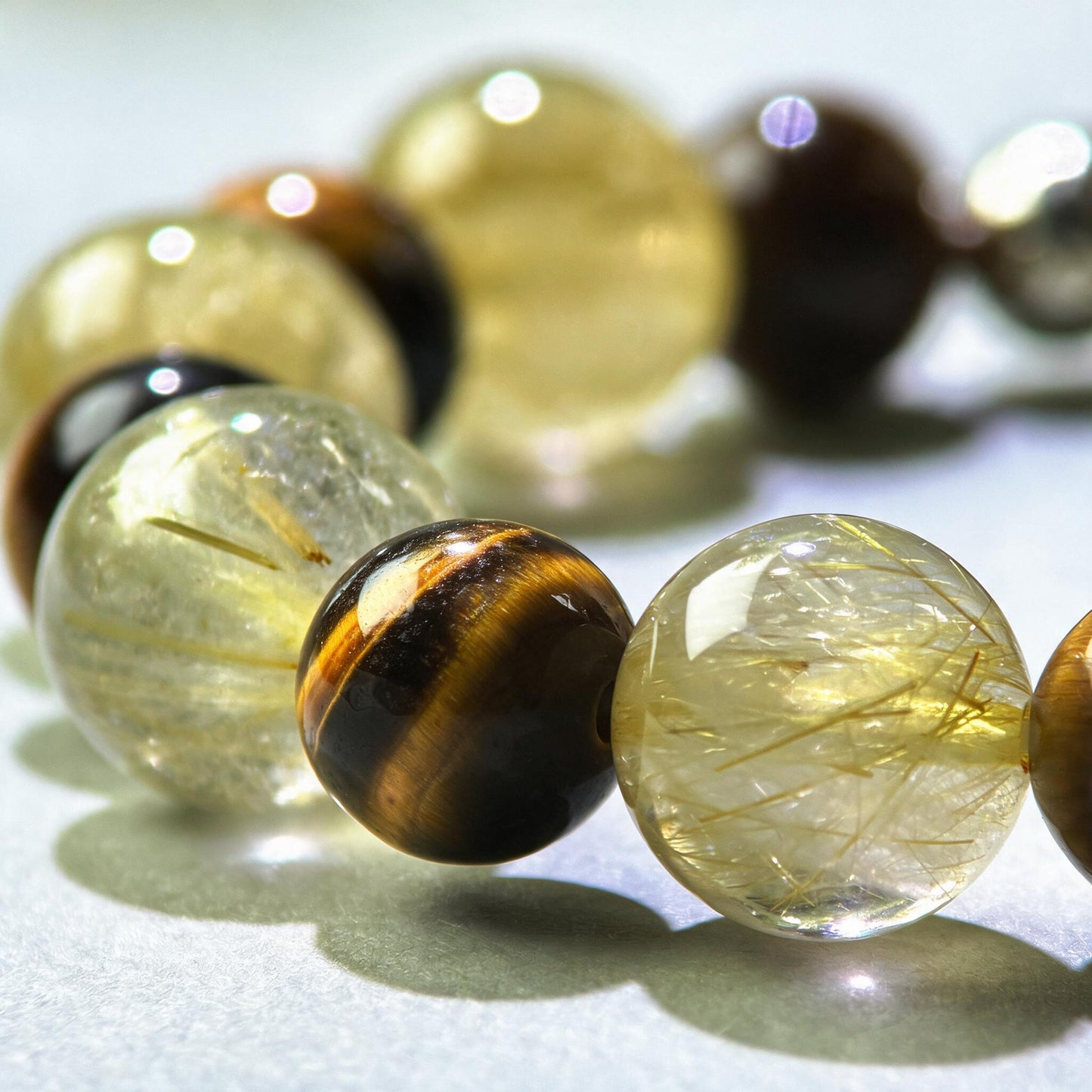 Close-up of Golden Rutilated Quartz and Tiger’s Eye beads in a crystal bracelet for steady focus