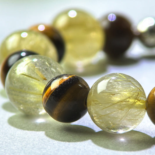 Close-up of Golden Rutilated Quartz and Tiger’s Eye beads in a crystal bracelet for steady focus