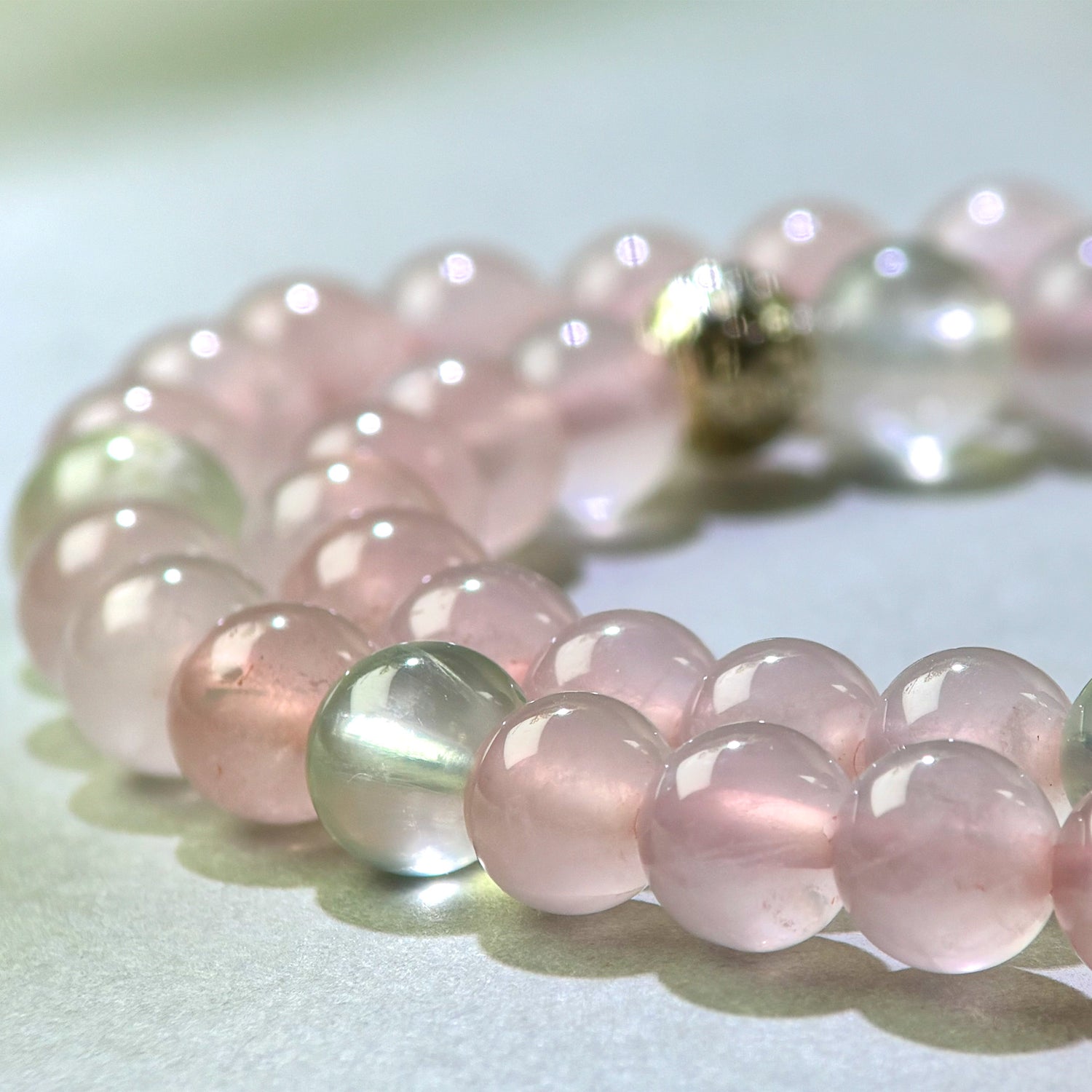 Close-up of Rose Quartz and Prehnite beads in a crystal bracelet for emotional openness and social expansion