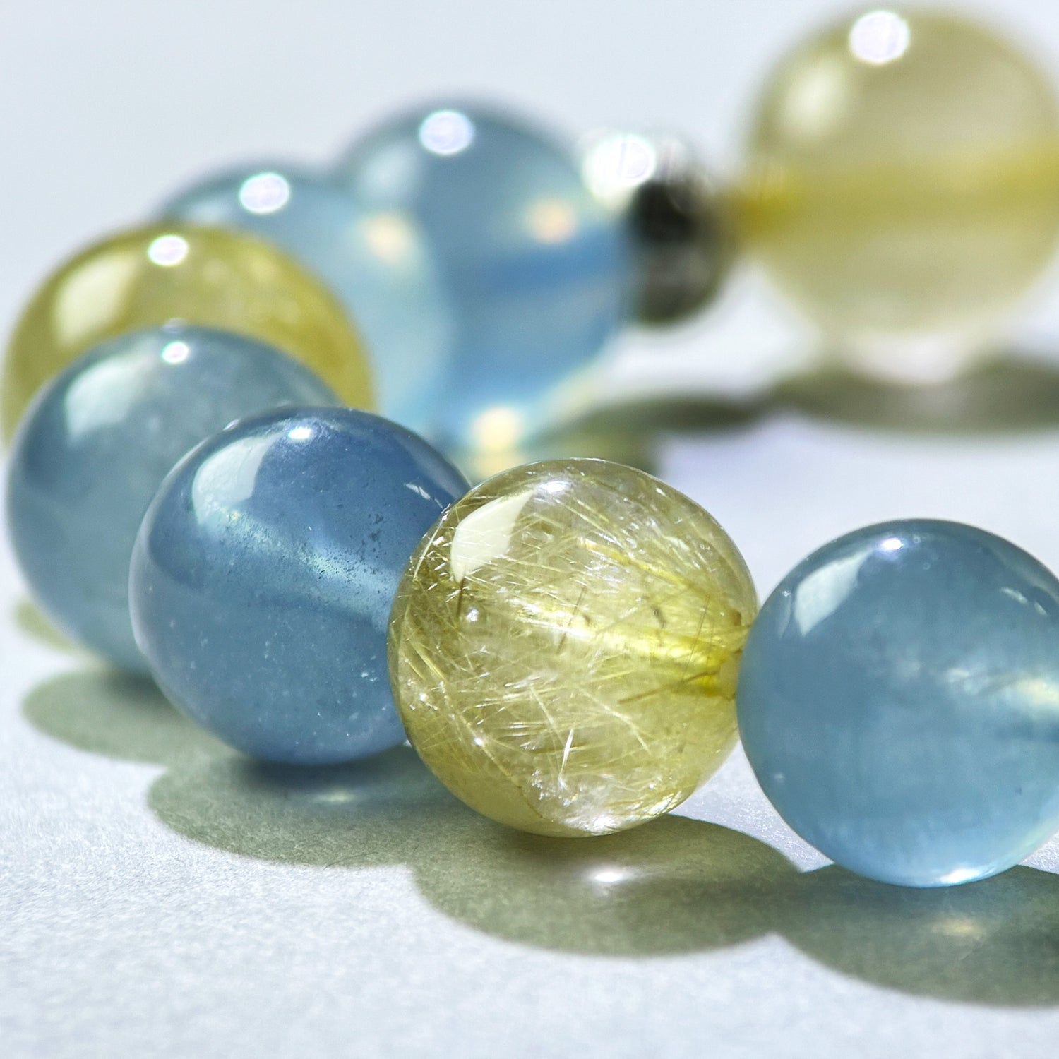 Close-up of Aquamarine and Golden Rutilated Quartz beads in a crystal bracelet for confident communication and stronger presence
