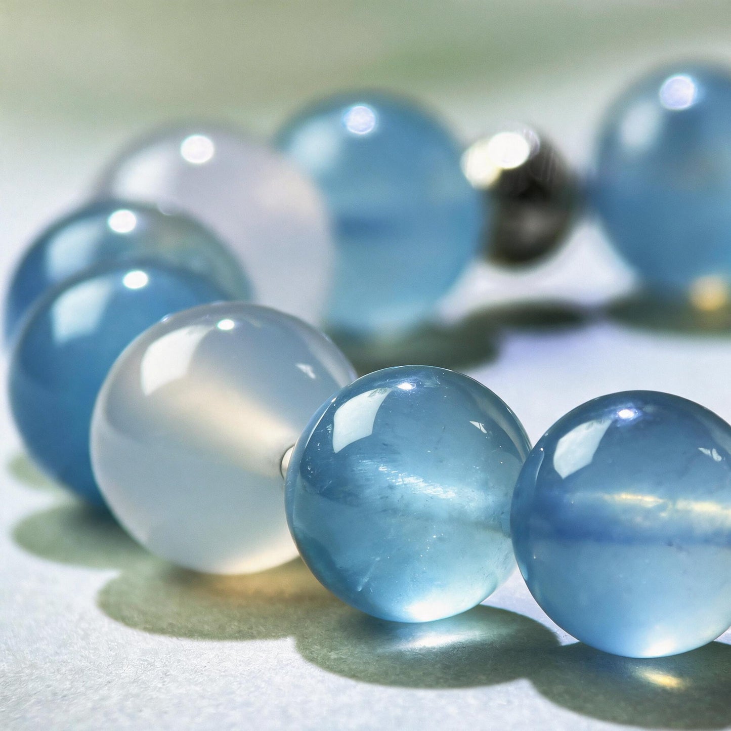 Close-up of Aquamarine and White Agate beads in a crystal bracelet for steadier communication and clearer responses