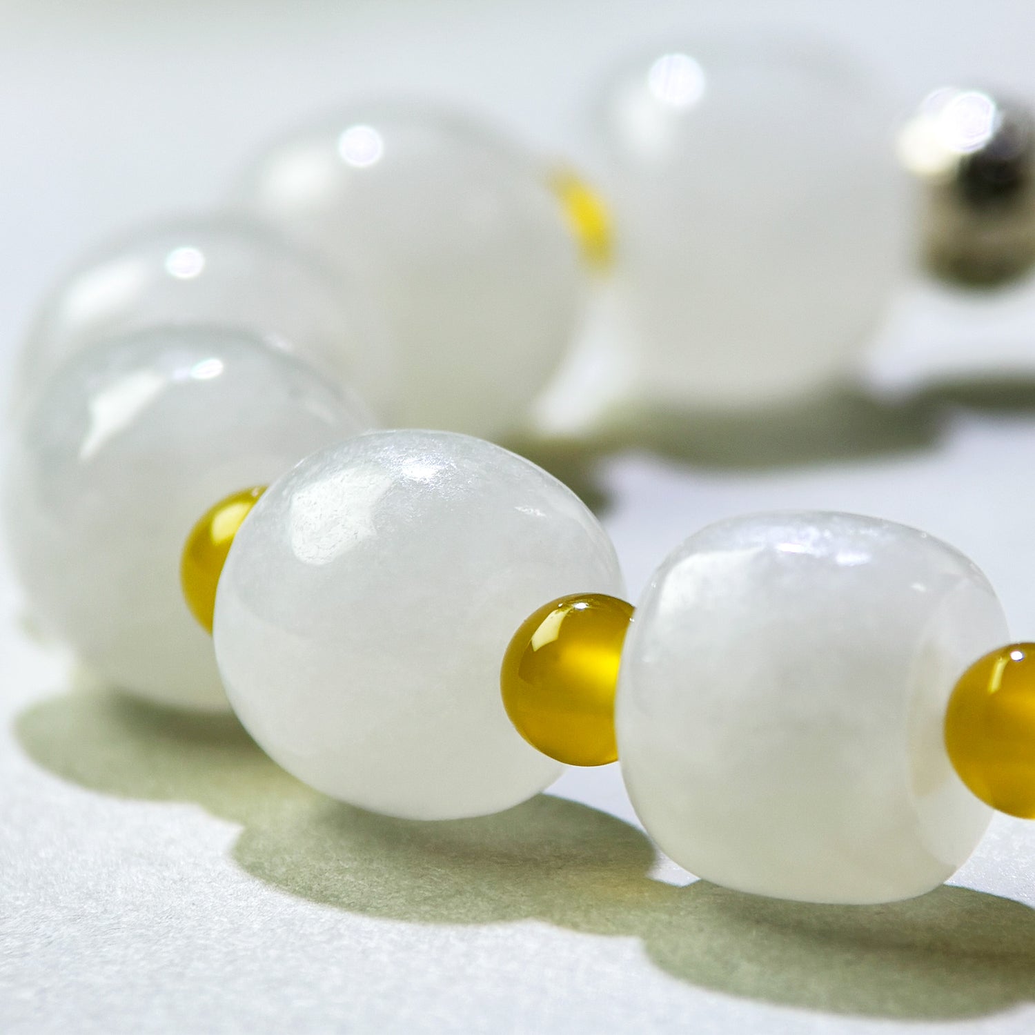 Close-up of White Hetian Jade and Yellow Agate beads in a crystal bracelet for a steadier internal state