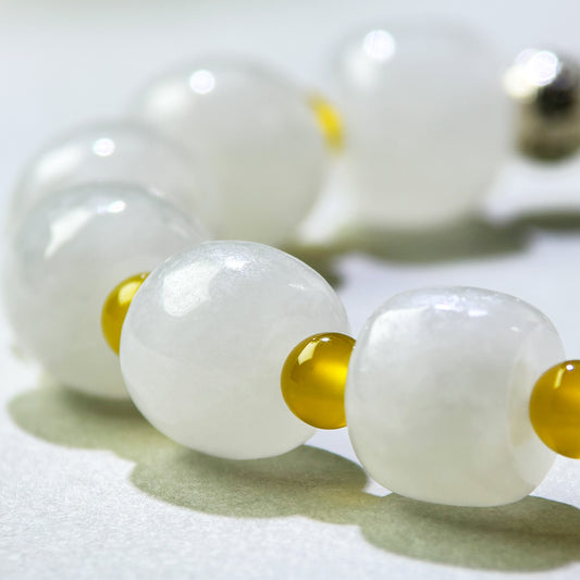 Close-up of White Hetian Jade and Yellow Agate beads in a crystal bracelet for a steadier internal state