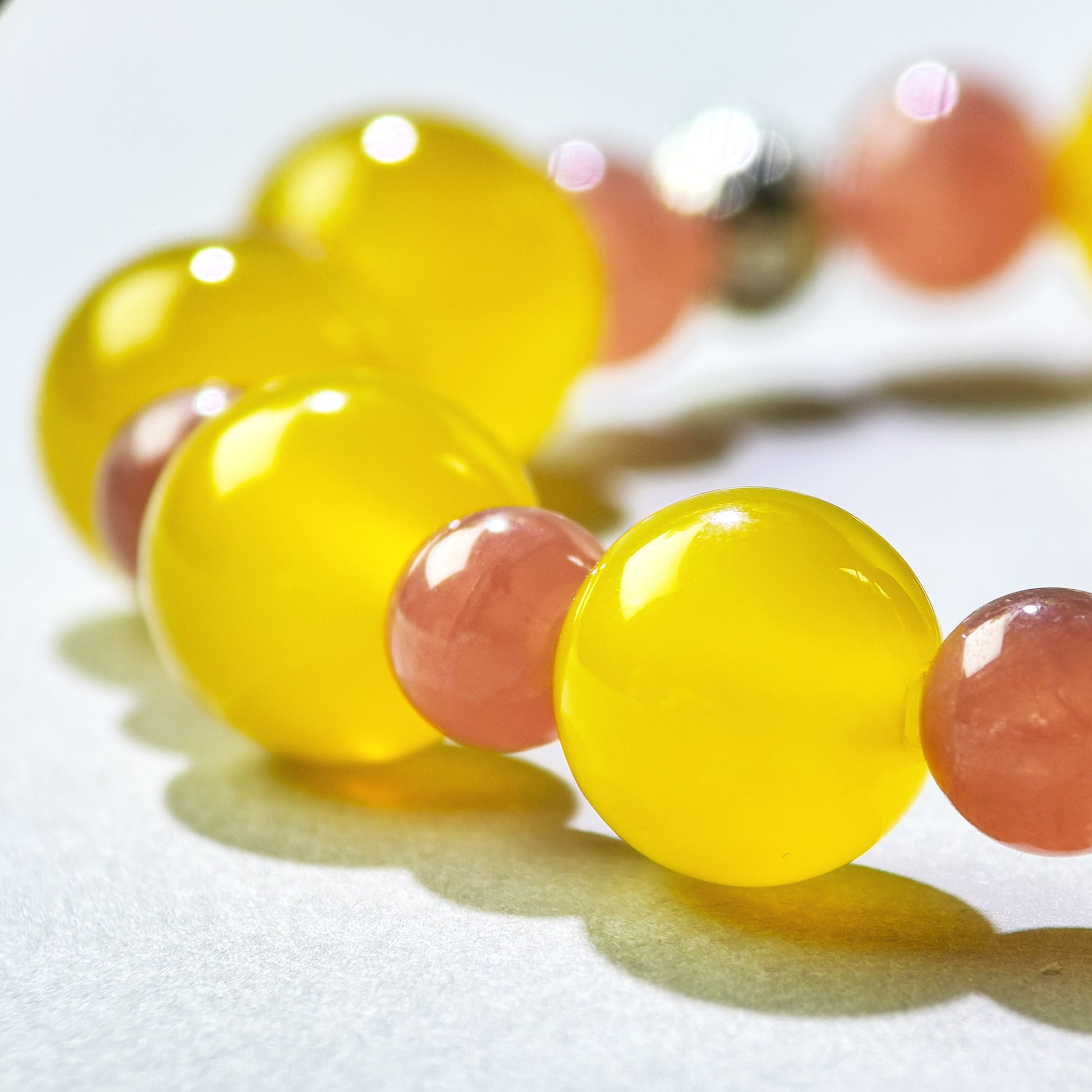 Close-up of Yellow Agate and Rhodochrosite beads in a crystal bracelet for emotional reconnection