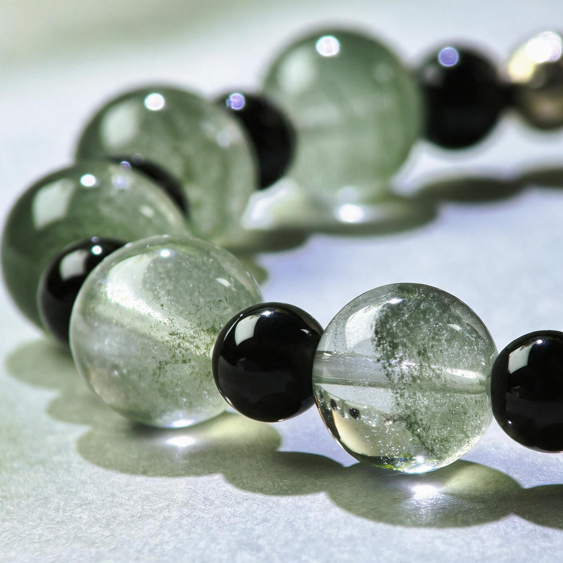 Close-up of Green Phantom Quartz and Obsidian beads in a crystal bracelet for staying steady in busy work environments