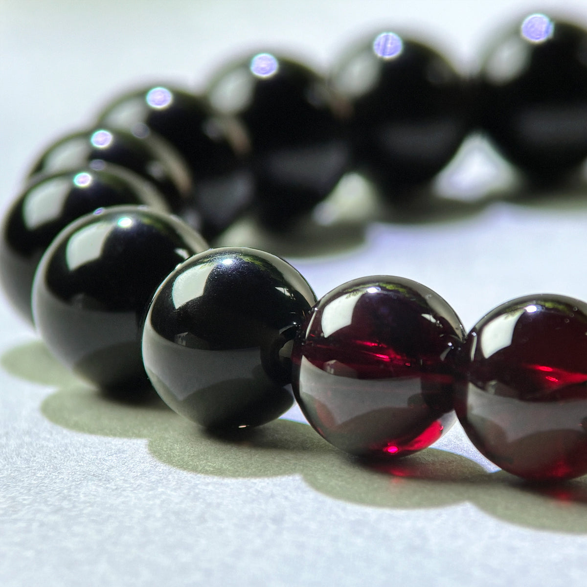 Close-up of Garnet and Black Tourmaline beads in a crystal bracelet for gently easing emotional numbness