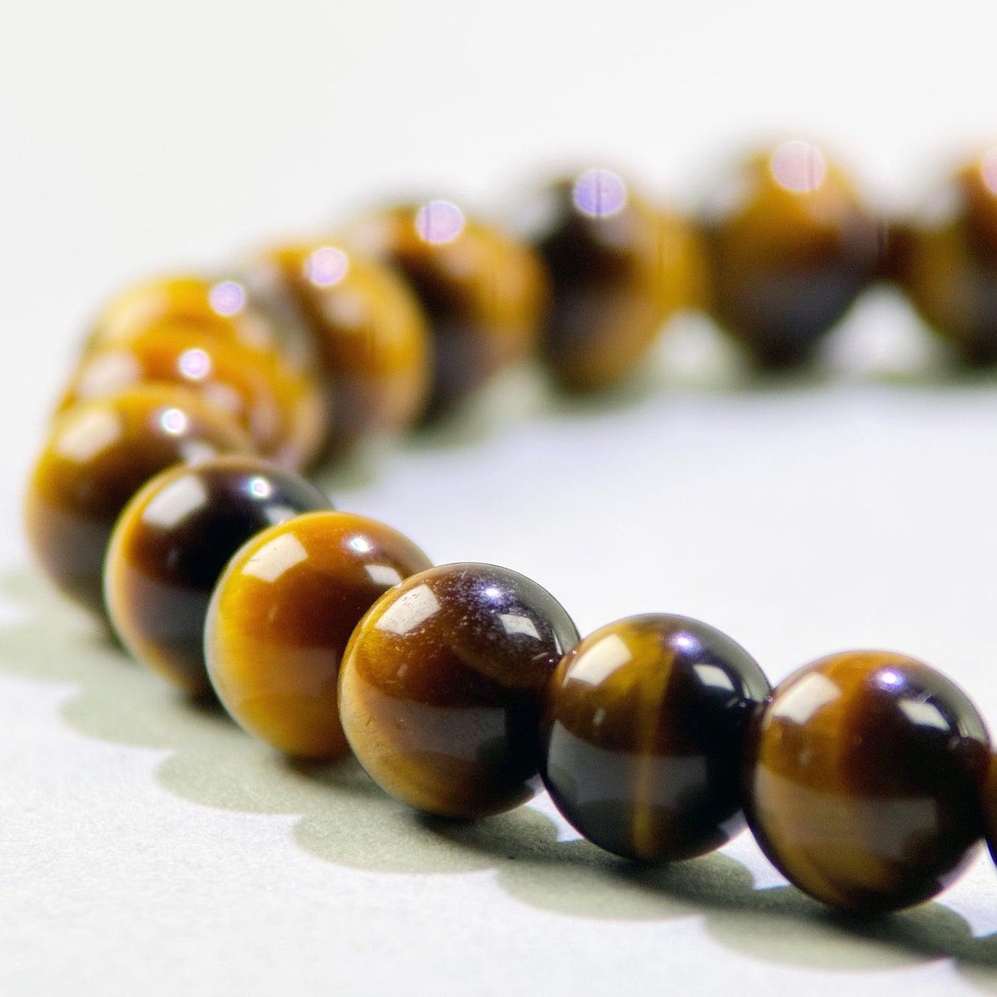 Close-up of Tiger’s Eye beads in a crystal bracelet for grounded focus and steady persistence