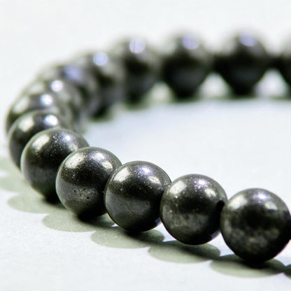 Close-up of Pyrite beads in a crystal bracelet for confidence around money, work, and financial opportunities
