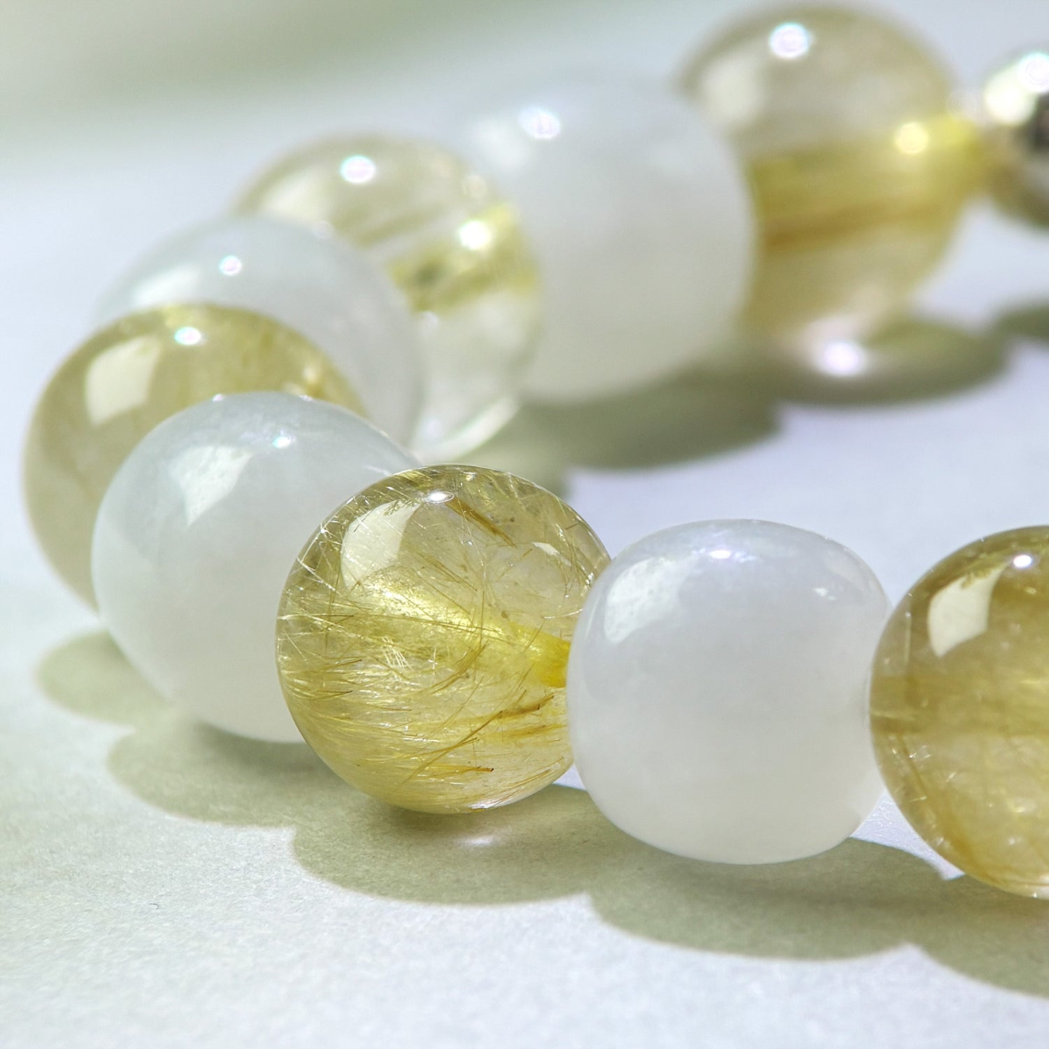 Close-up of Golden Rutilated Quartz and White Hetian Jade beads in a crystal bracelet for steadier responses and clearer internal boundaries