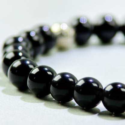 Close-up of Black Tourmaline and Obsidian beads in a crystal bracelet for protection and emotional release