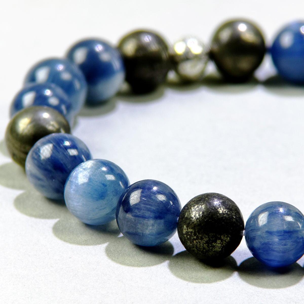 Close-up of Blue Kyanite and Pyrite beads in a crystal bracelet for self-expression, willpower, and pursuit