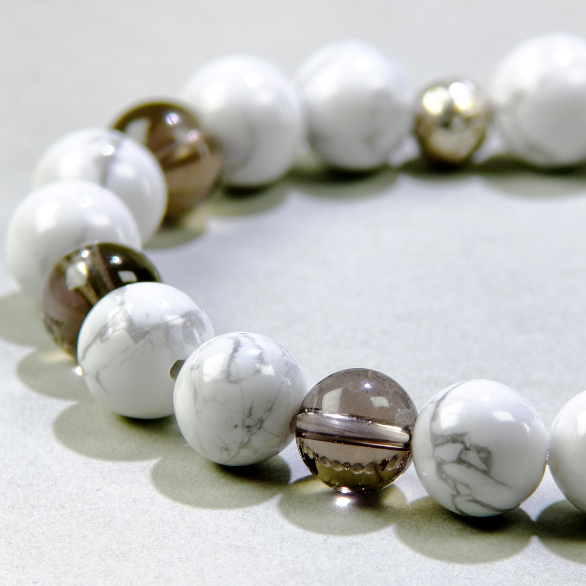 Close-up of Howlite and Smoky Quartz beads in a crystal bracelet for patience, calm, and grounding