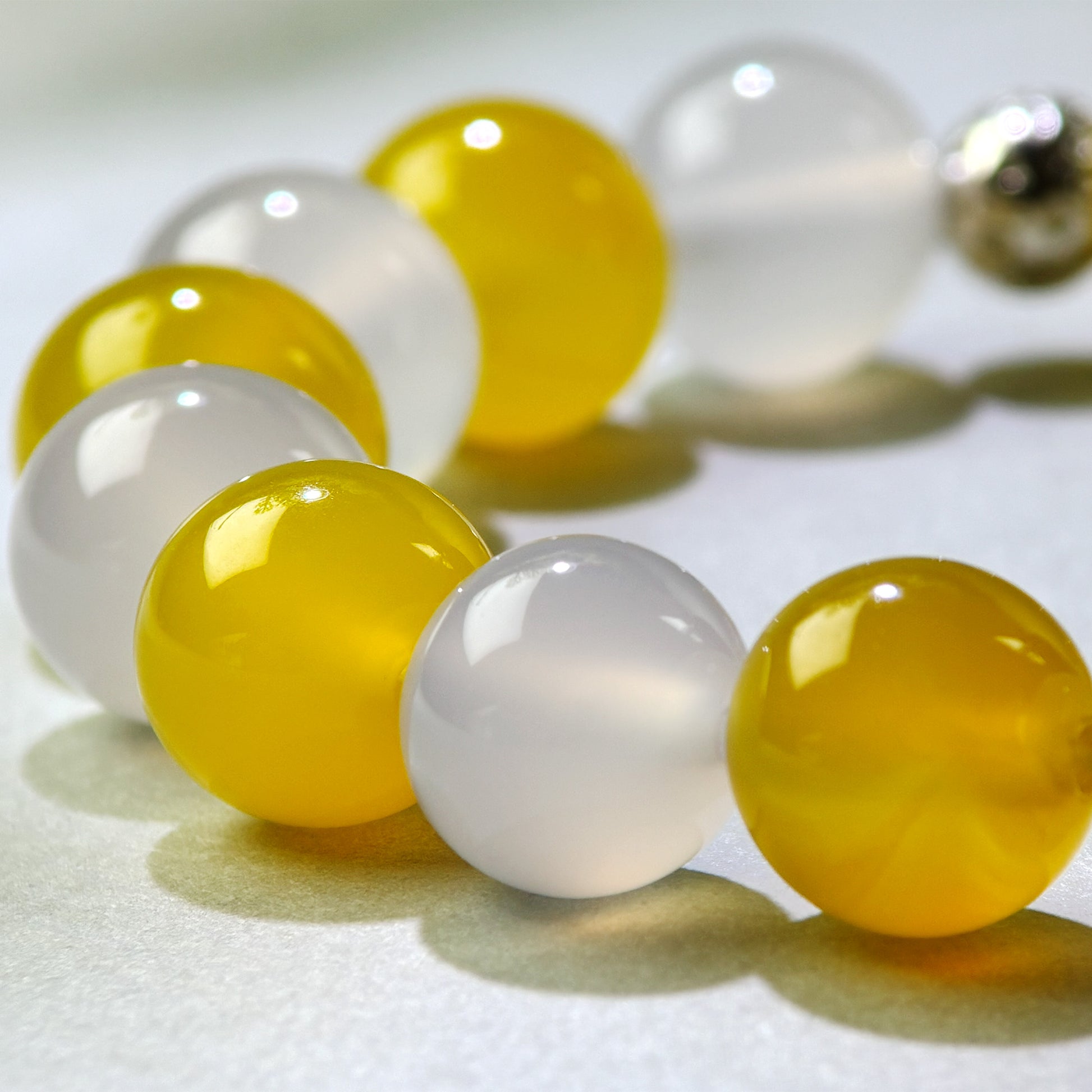 Close-up of Yellow Agate and White Agate beads in a crystal bracelet for mental slowing and a clearer sense of completion