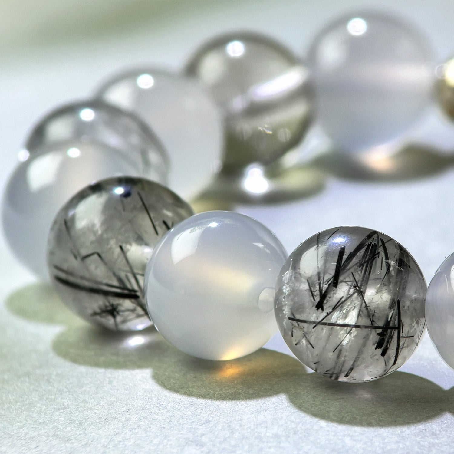 Close-up of White Agate and Black Rutilated Quartz beads in a crystal bracelet for calmer mental processing