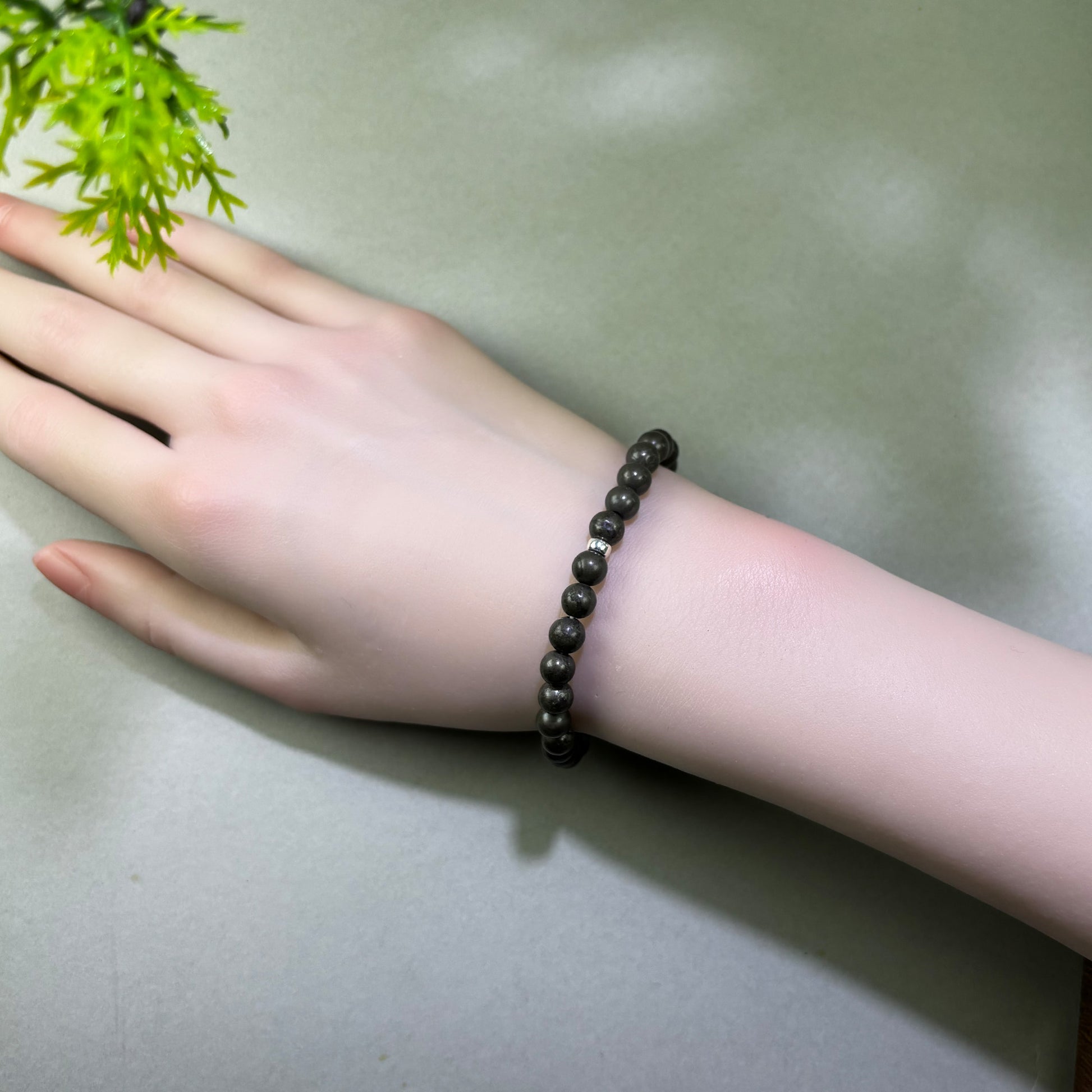 Pyrite bracelet worn on wrist for greater confidence in money decisions, negotiation, and practical opportunities