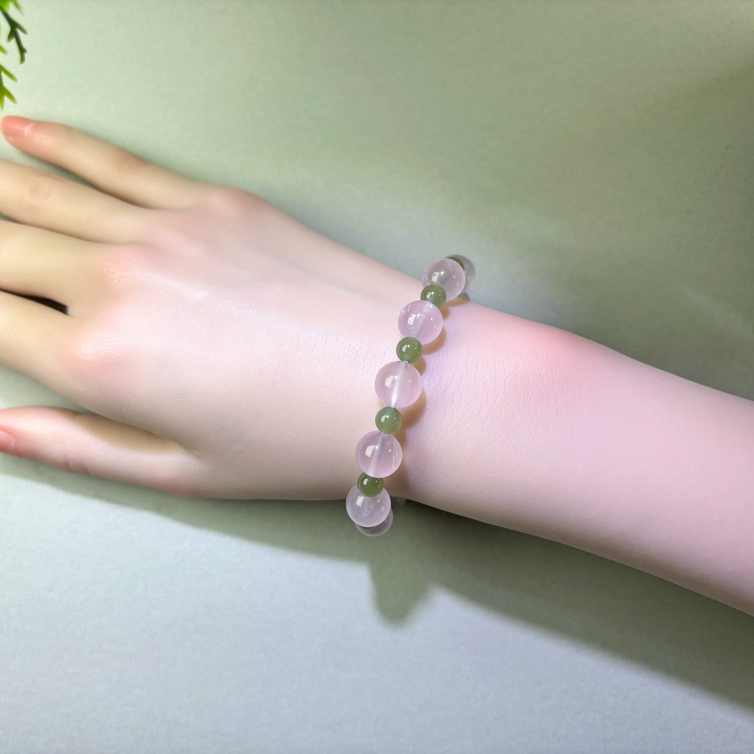 Rose Quartz and Green Hetian Jade bracelet worn on wrist for feeling more secure in relationships